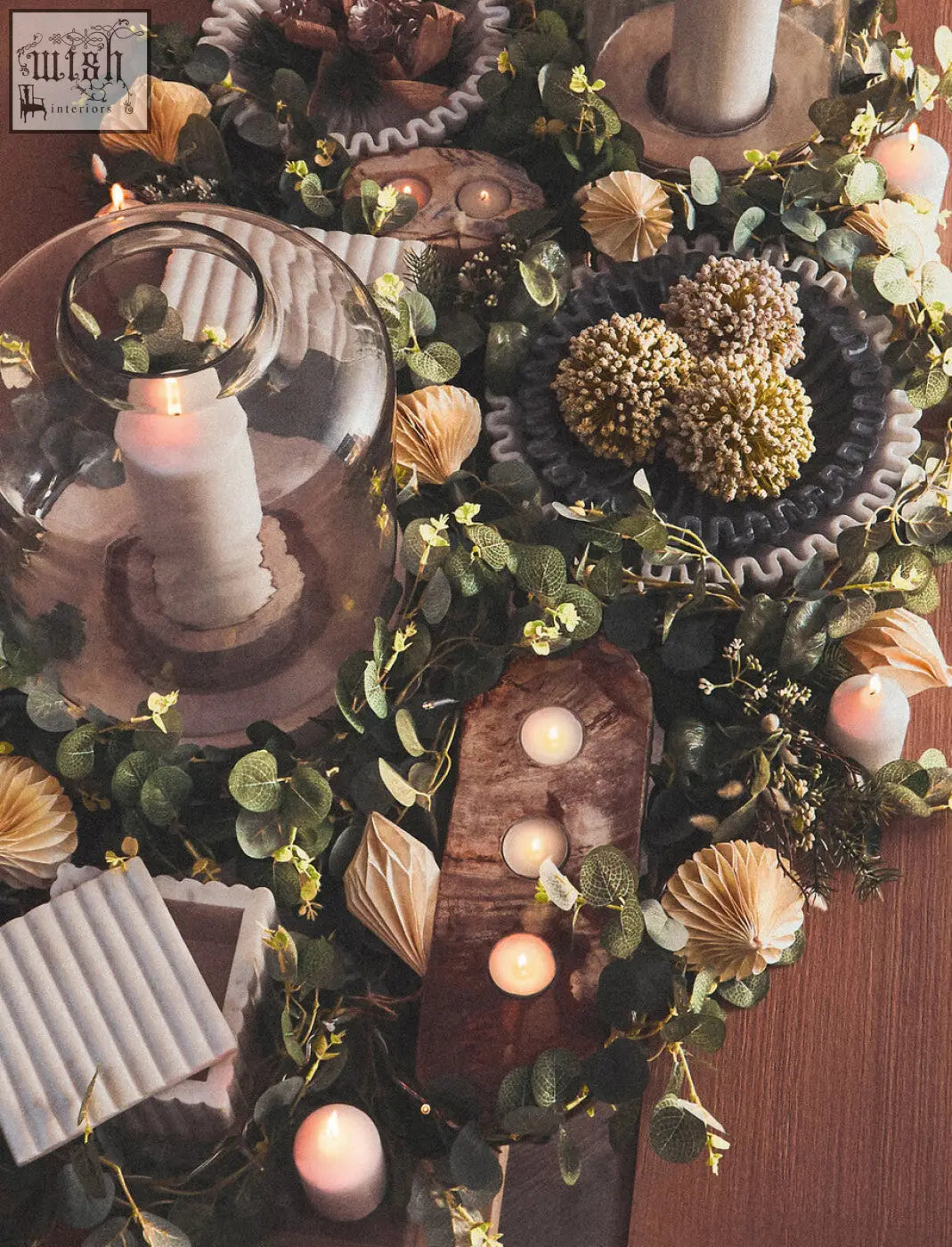 A rustic wooden candle holder with a weathered finish and three circular spots next to a white fluted marble box