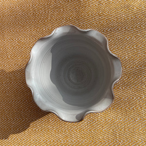 A light gray ceramic scalloped bowl with subtle speckles shown as a scalloped brown vase pot alternative