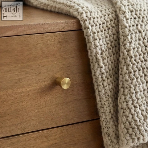 Gold-toned cylindrical drawer knob on a scandinavian light walnut oslo bedside table with light walnut finish