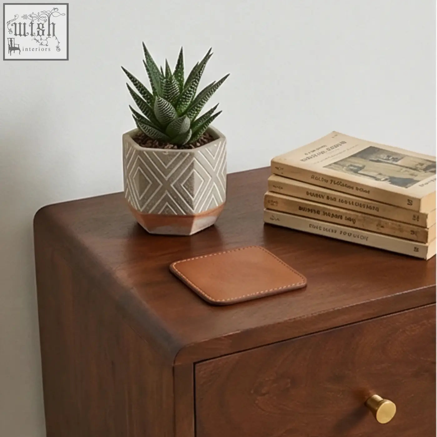 Brown leather coaster with stitched edges on scandinavian walnut logan narrow bedside table measuring 30cm wide