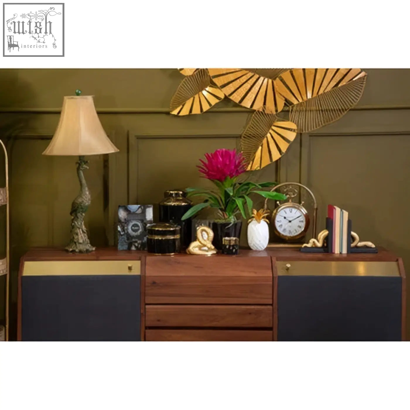 Wooden sideboard with dark blue panels and brass accents next to a white marble sena pineapple jar