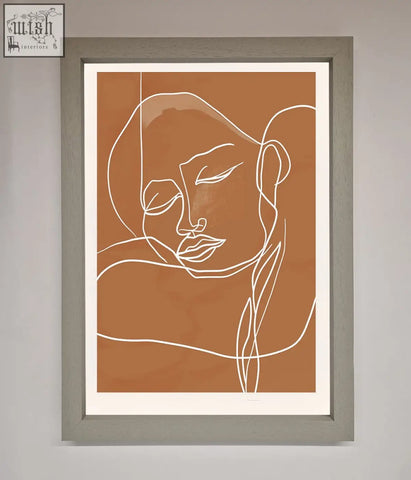 A minimalist sepia lines framed wall art with white continuous line portrait in a gray frame on brown background