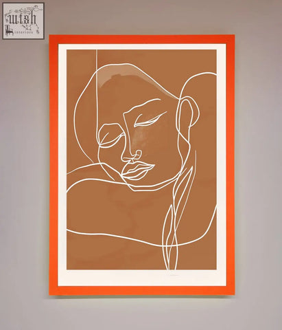 Sepia lines framed wall art featuring orange-framed minimalist line art portrait of a serene face on tan background
