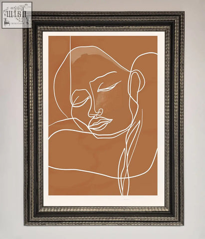 A minimalist sepia lines framed wall art with a serene white line-art face on terracotta background in dark gray frame