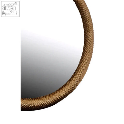 A serpent wall mirror with a round shape and dramatic texture gold toned rope like frame for wall decor