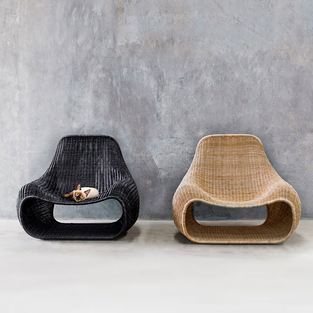 Two serrano outdoor lounge chairs in black and beige wicker with footstools featuring sleek curved woven design