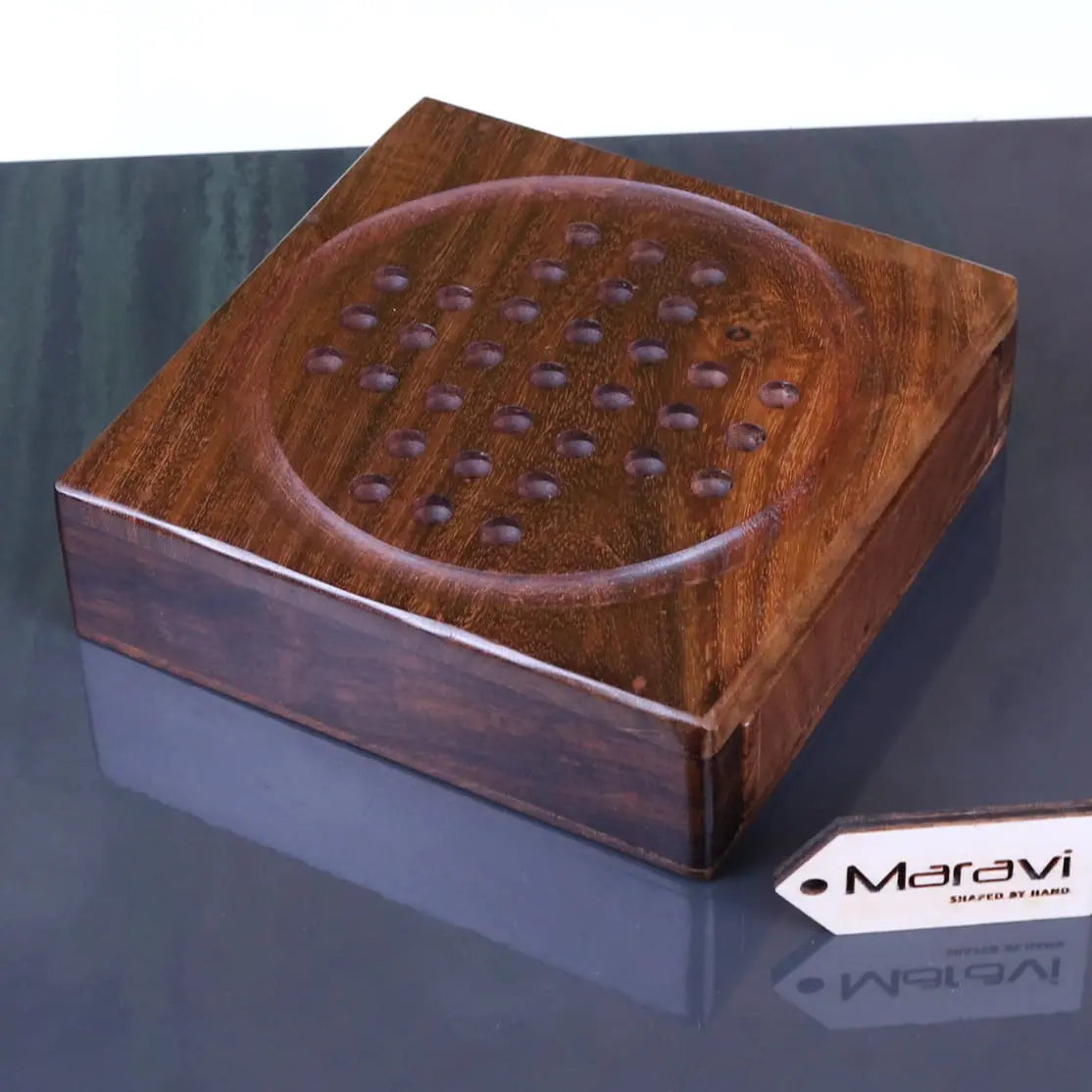 A sesih pocket solitaire game wooden board with rich brown finish and engraved circular holes for steel marbles