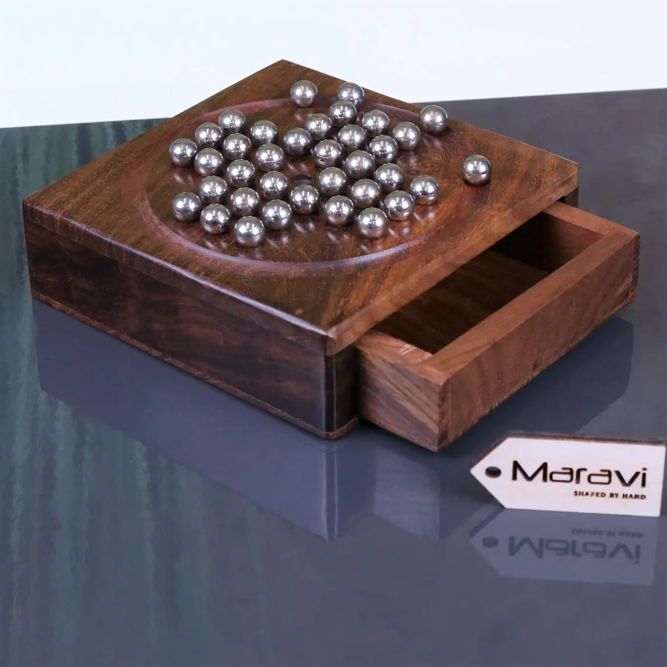 Wooden sesih pocket solitaire game with a drawer and silver steel marbles arranged on top for easy play