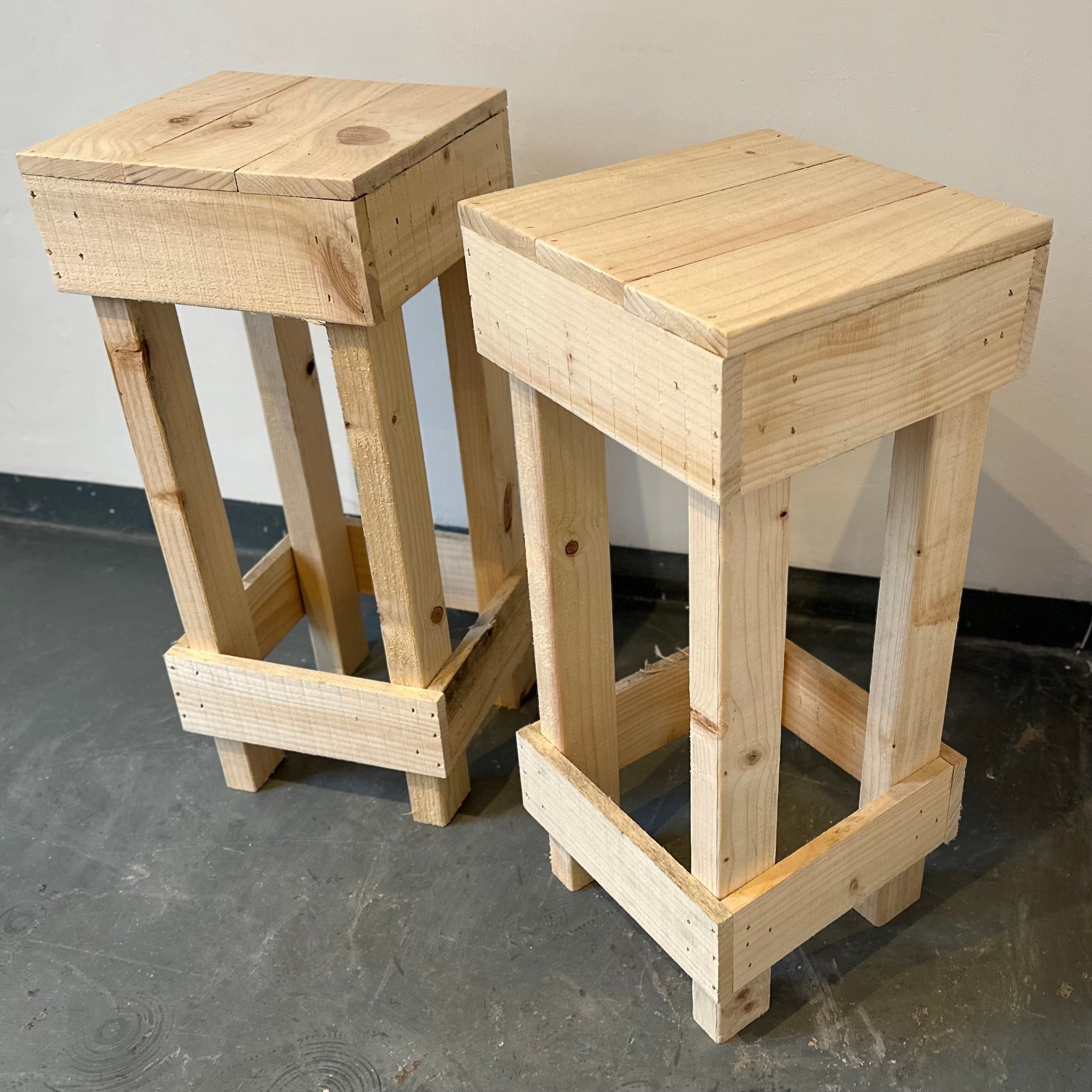 Set of 2 rustic wooden bar stools with light unfinished wood and visible grain perfect for casual seating