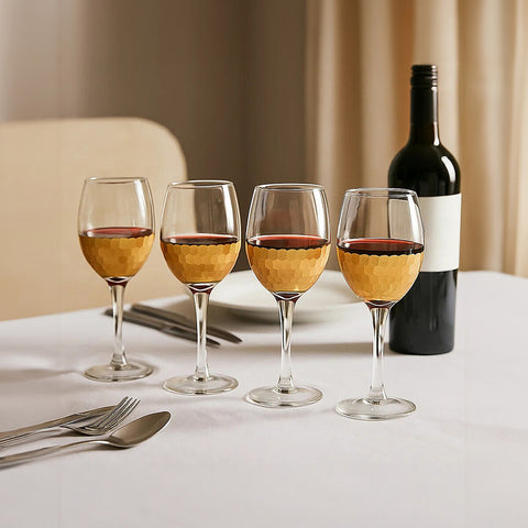 Set of four astrid small wine glasses with clear glass and hammered gold finish bowls filled with red wine