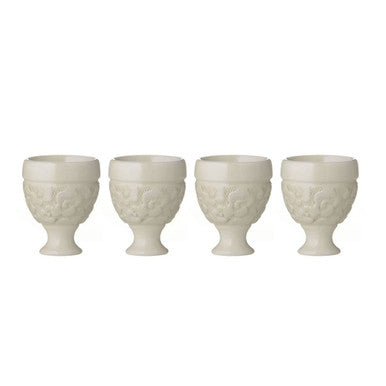 Set of four cream-colored ceramic georgia egg cups with intricate floral embossing and classic pedestal base