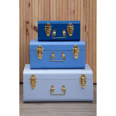 Stacked three assorted blue storage trunks with vintage style gold hardware and central handles for easy carrying