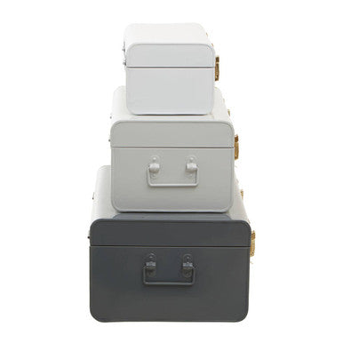 Stacked set of four vintage-style metal storage trunks in white and grey with brass hardware for stylish grey storage