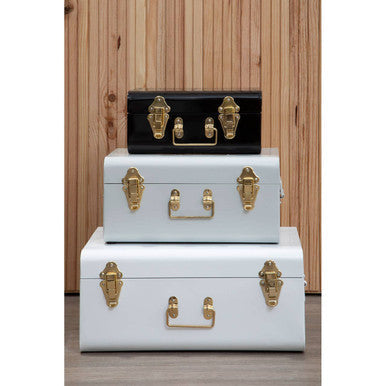 Set of three monochrome storage trunks with vintage style metal construction and gold-tone hardware for stylish storage