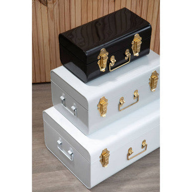 Stacked glossy black and matte white vintage storage trunks with gold hardware in set of three monochrome storage trunks