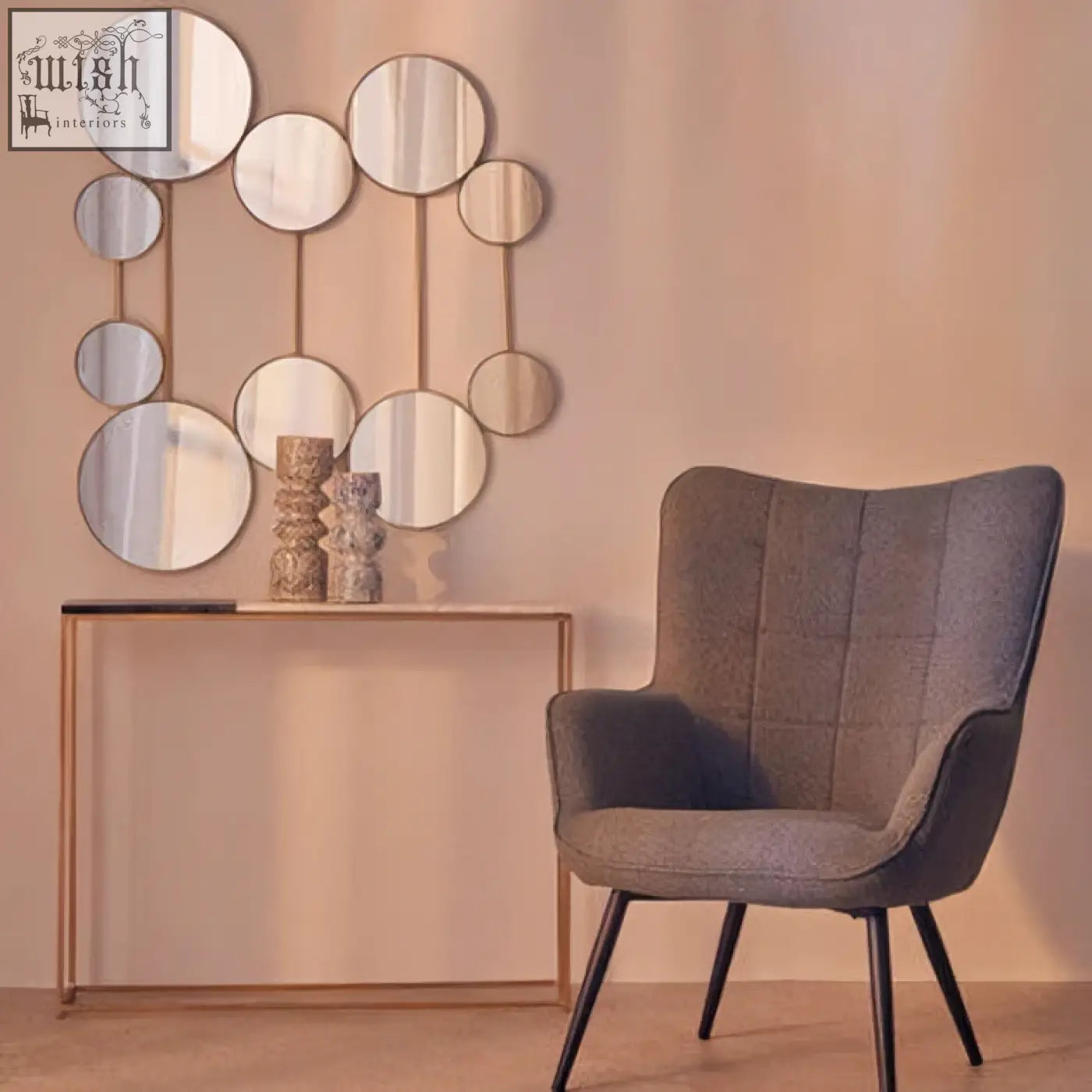 Gray tufted armchair with black metal legs next to a medium speckled vase perfect for stylish home decor