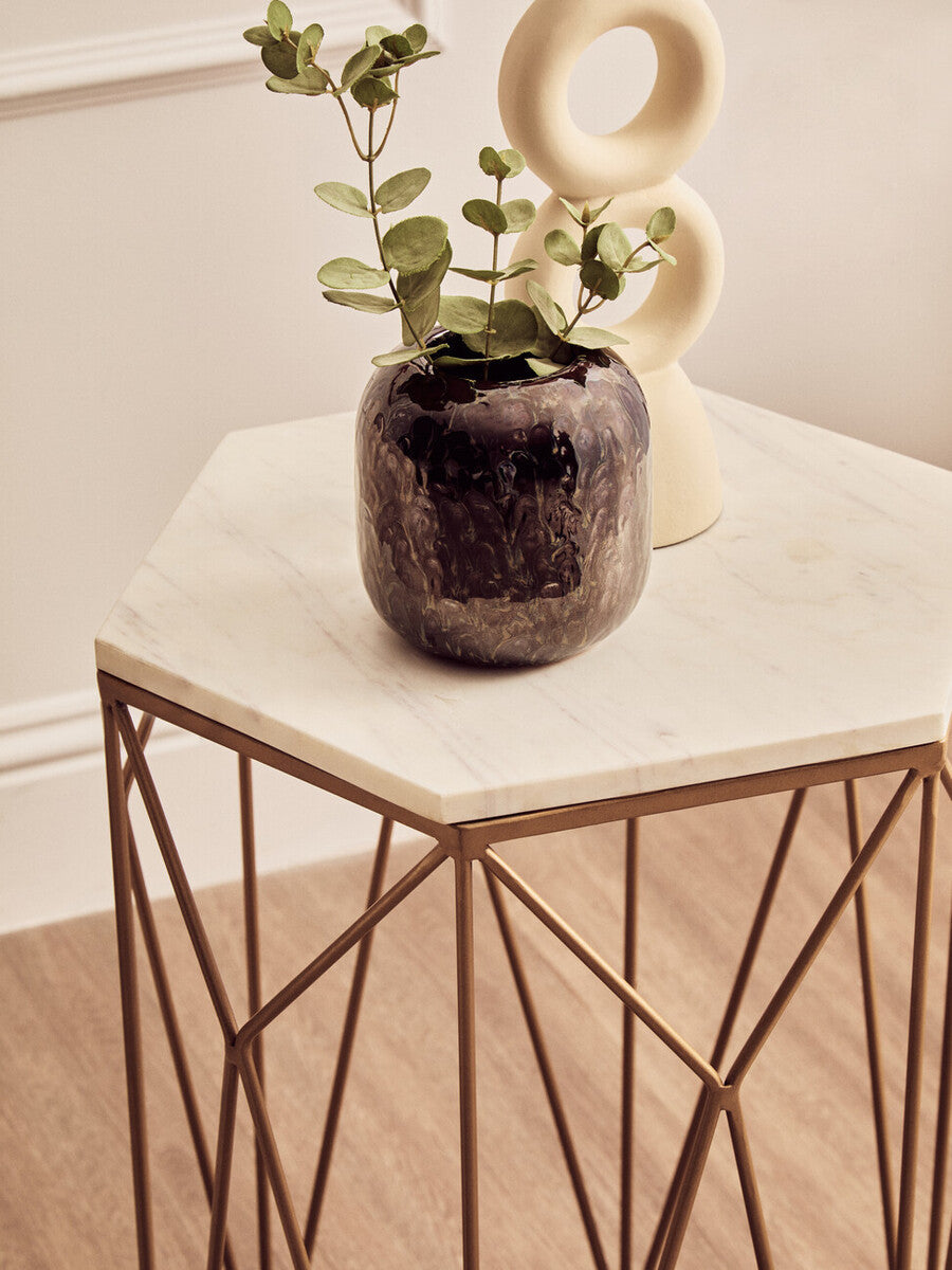 Dark textured ceramic vase with eucalyptus leaves on shalimar marble top side table with geometric base and marble surface
