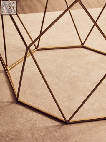 Shalimar octagon white marble coffee table with gold-toned geometric metal frame and intersecting triangular lines