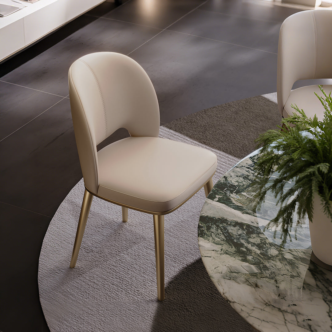 Cream-colored shankar leather dining chair with slender gold-tone metal legs perfect for stylish dining spaces