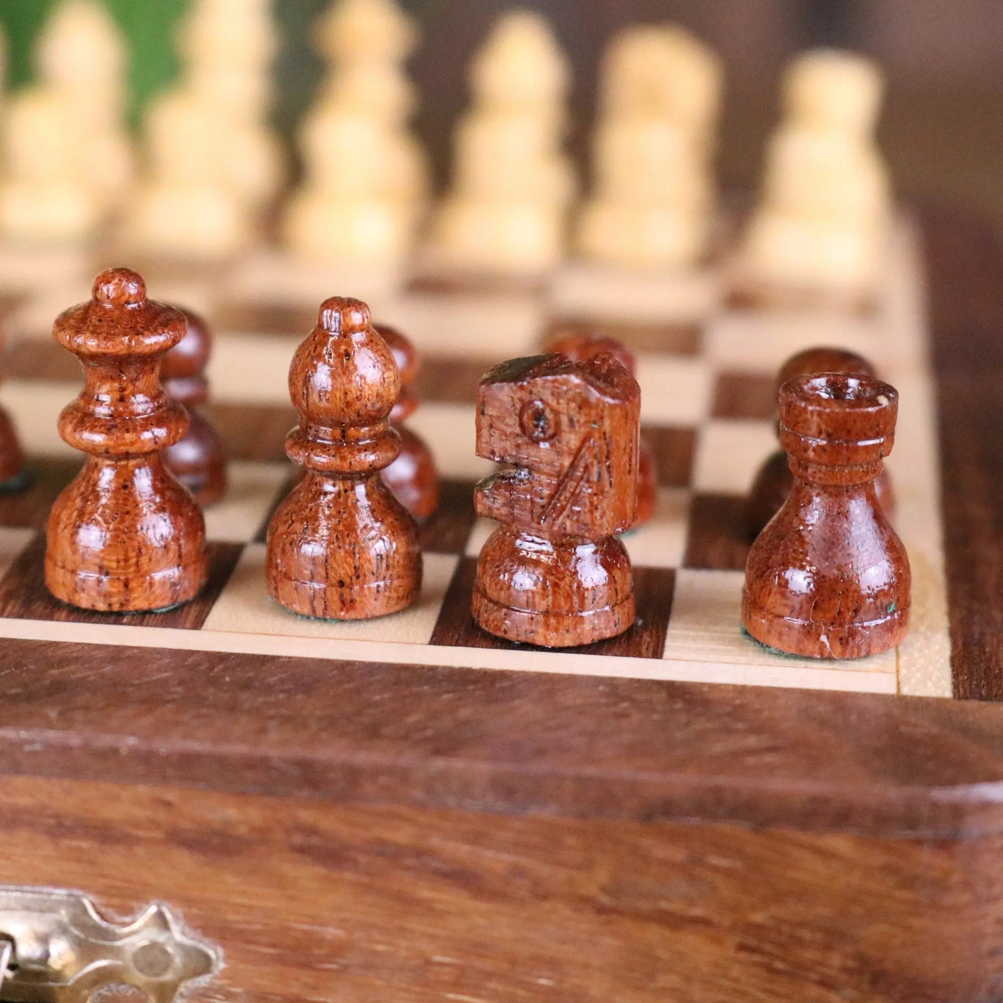 Polished wooden chess pieces with warm brown finish and natural grain in shatranj folding wooden chess set 14cm