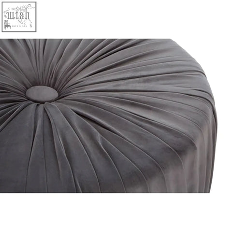 A plush dark gray velvet shea grey footstool with a circular tufted center and radiating pleats perfect for lounging