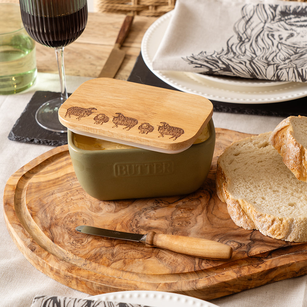 Olive green ceramic butter dish with a light wood lid engraved with sheep silhouettes for stylish storage