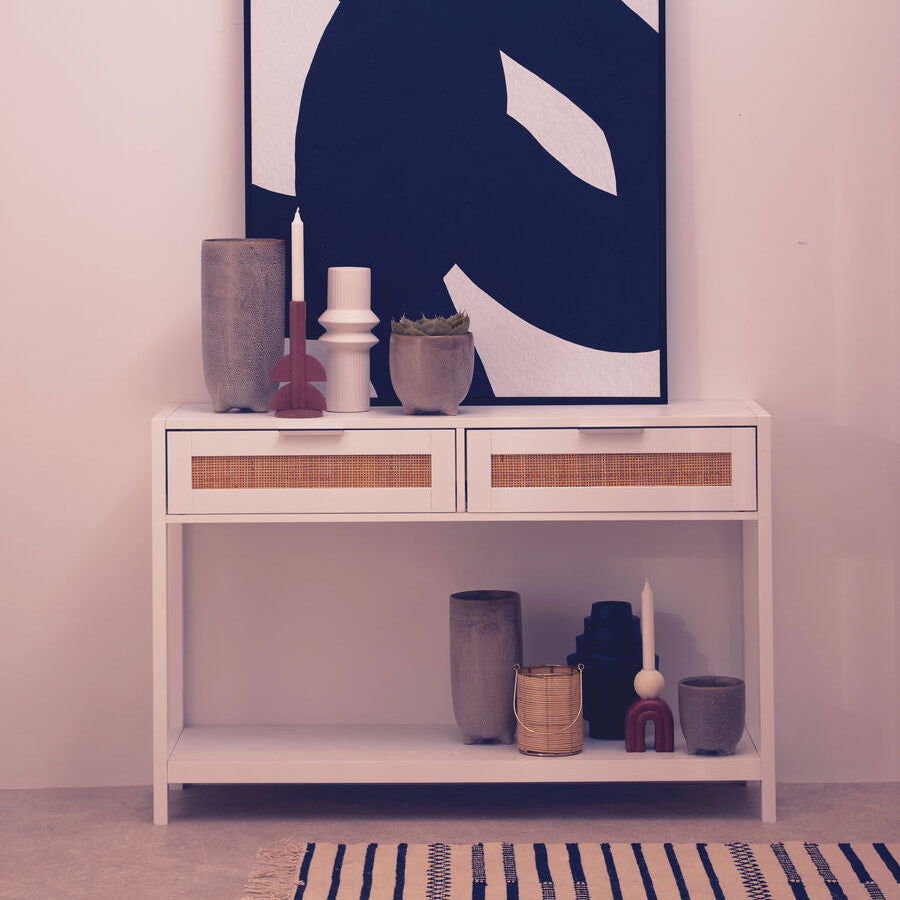 White wood and rattan two drawer console table with woven cane fronts and open shelving below for storage