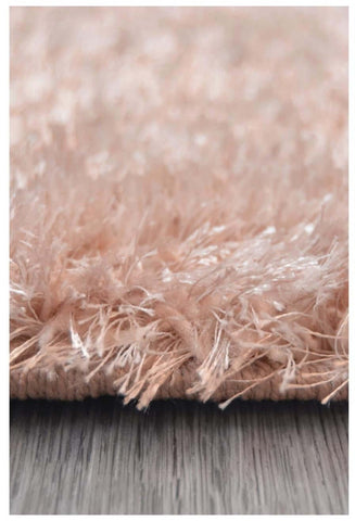 A plush peach-colored shimmer pink supersoft shaggy rug with a soft textured surface and slightly frayed edges