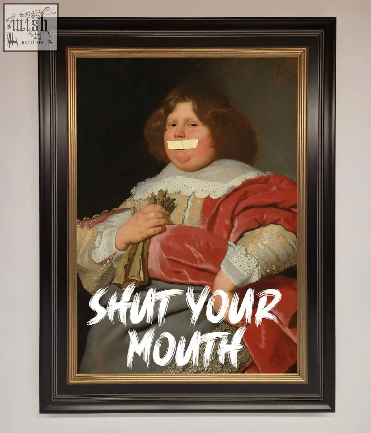 A bold statement framed print of a child in red velvet with white lace collar and tape over mouth shut your mouth design