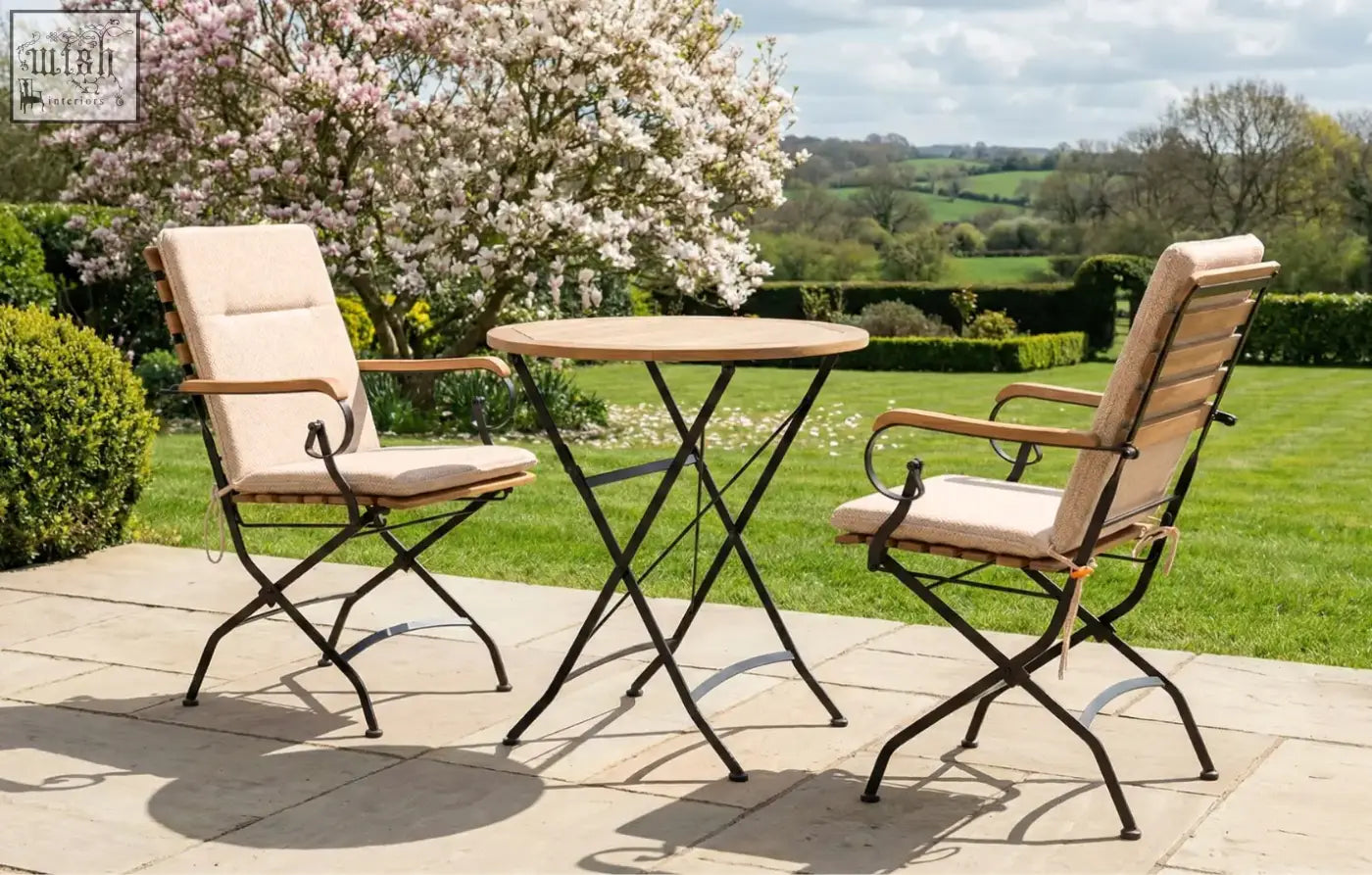 Beige cushioned folding chair with wooden armrests and black metal frame in sicily 2 seater garden dining set with grade ab teak