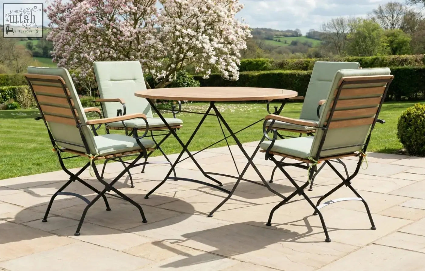Set of four folding garden chairs with light green cushions and wooden backs paired with a grade ab teak seater dining set