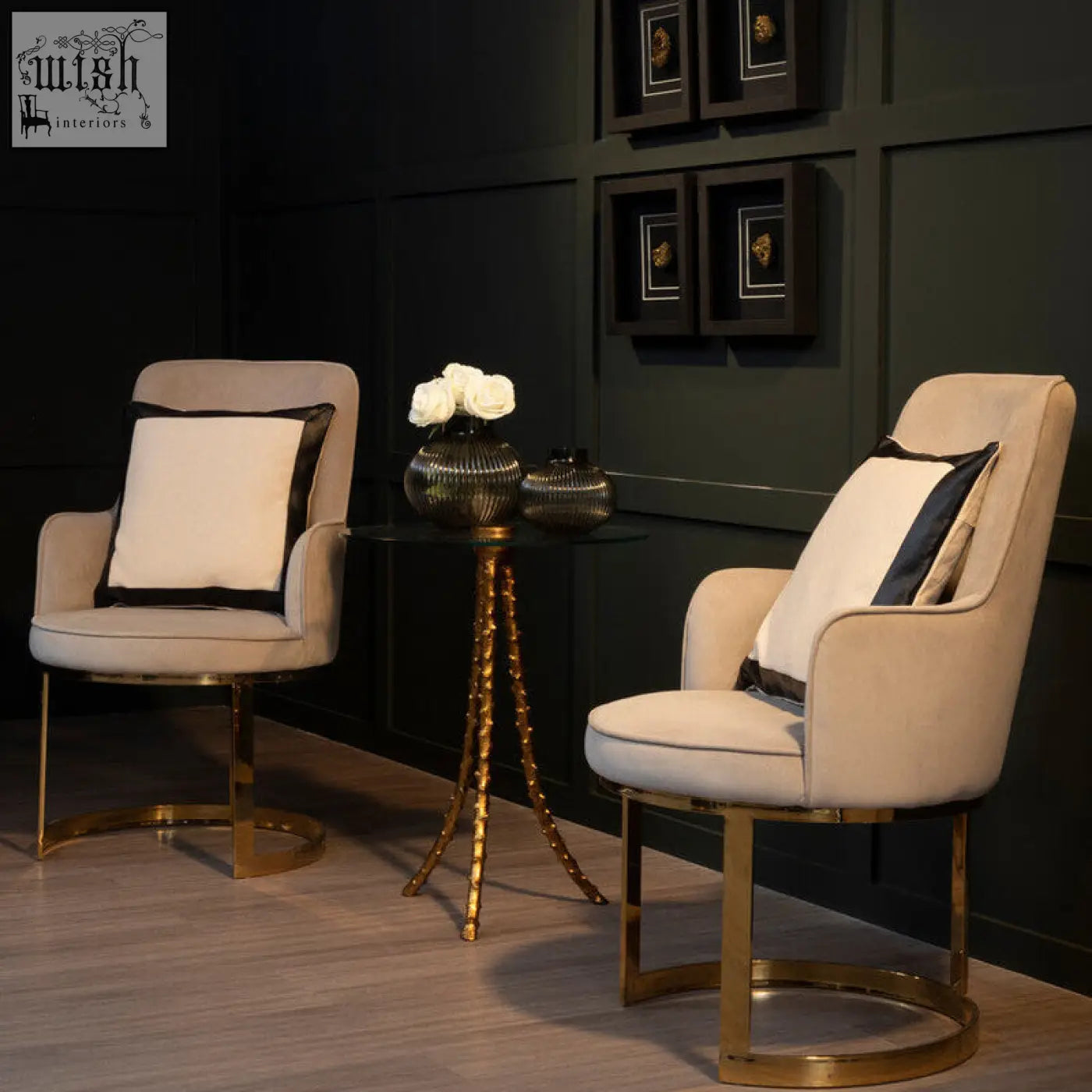 Beige upholstered armchairs with warm gold triple-leg base and black-trimmed pillows near sika large side table