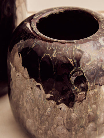 A glossy black ceramic silas dark blue planter with swirling gold and silver marbled patterns perfect for home decor