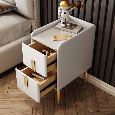 White upholstered Silva bedside table with gold-tone drawer pulls wooden legs and marble-patterned top surface