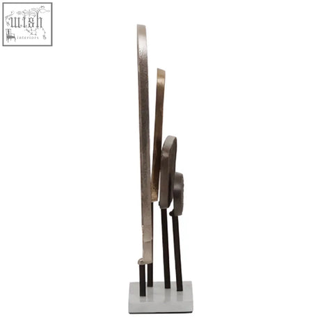 Modern abstract simbolo small assorted metal sculpture with silver gold and bronze rings on a white marble base