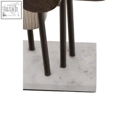Dark metal legs support a simbolo small assorted colour metal sculpture with textured elements on a white marble base