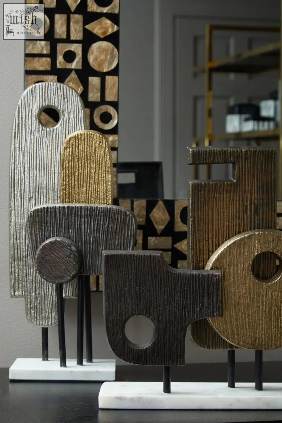 Simbolo small assorted metal sculpture with silver gold and dark wood finishes on a marble base with textured shapes