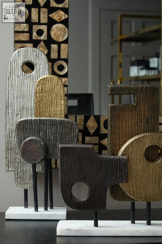 Simbolo small assorted metal sculpture with silver gold and dark wood finishes on a marble base with textured shapes