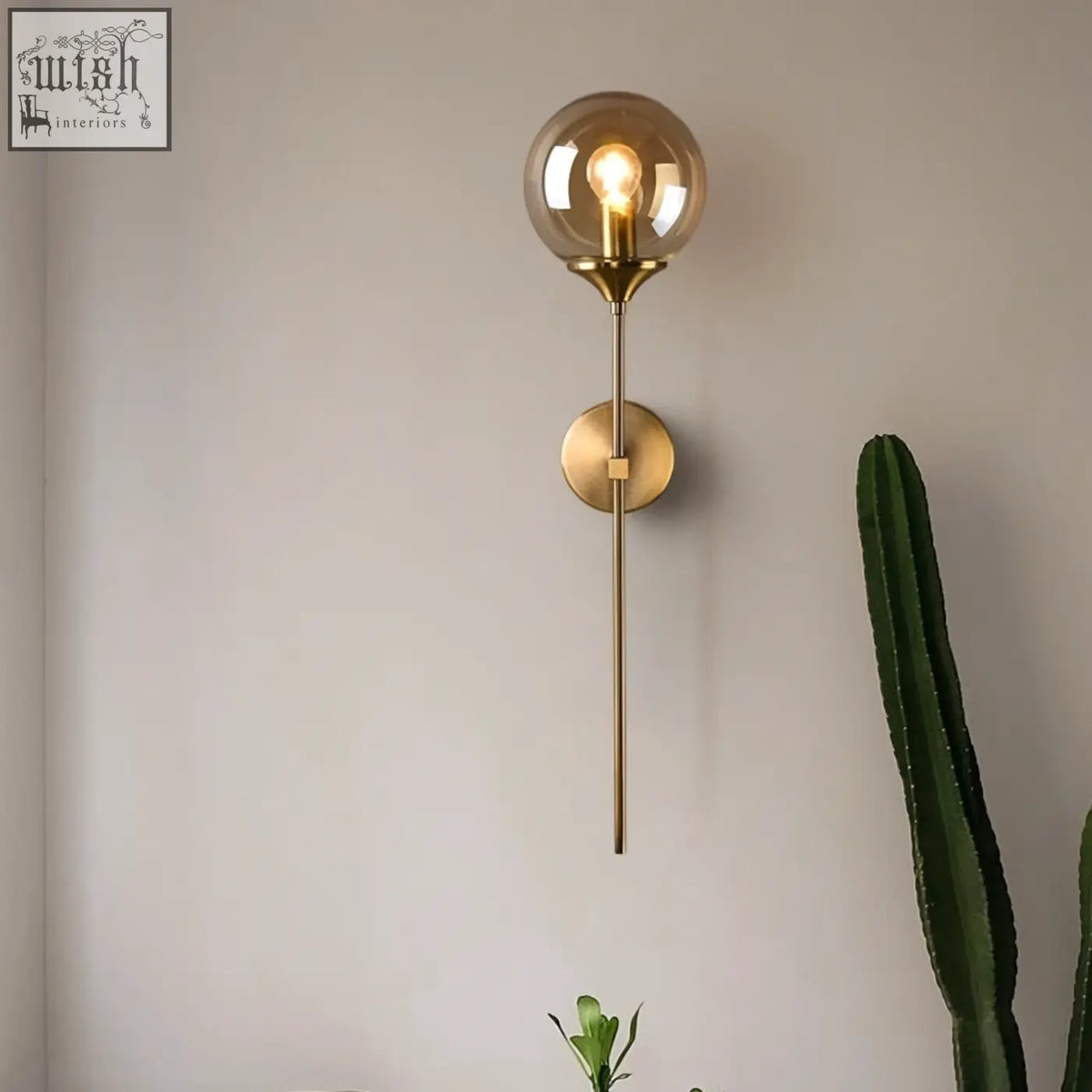 Brass-finished sizzle glass wall light with spherical amber glass globe and exposed filament bulb for warm ambient lighting