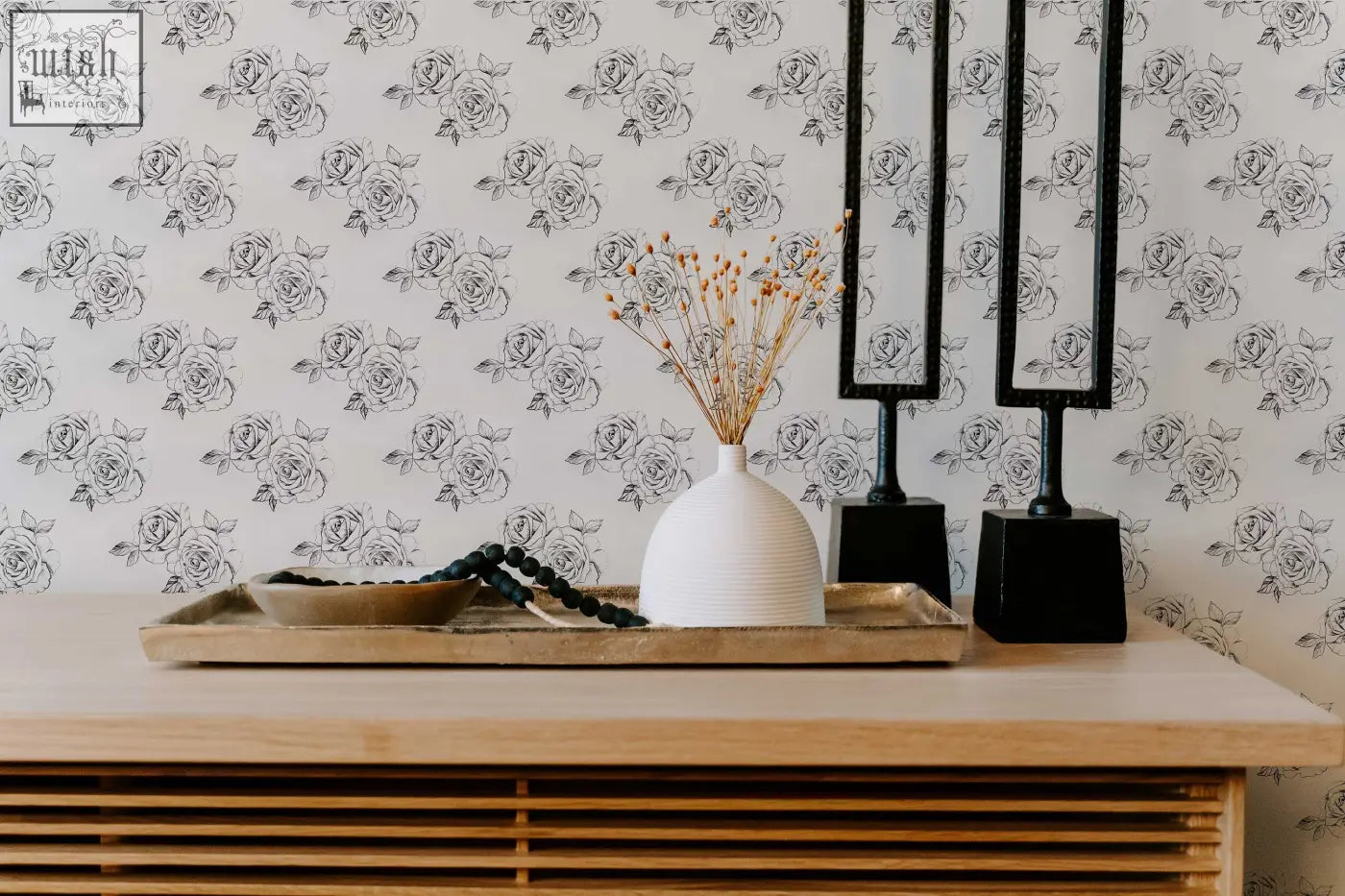 White ceramic vase with vertical ridges holding dried stems on black and white sketch rose peel and stick wallpaper perfect for living space ordering process