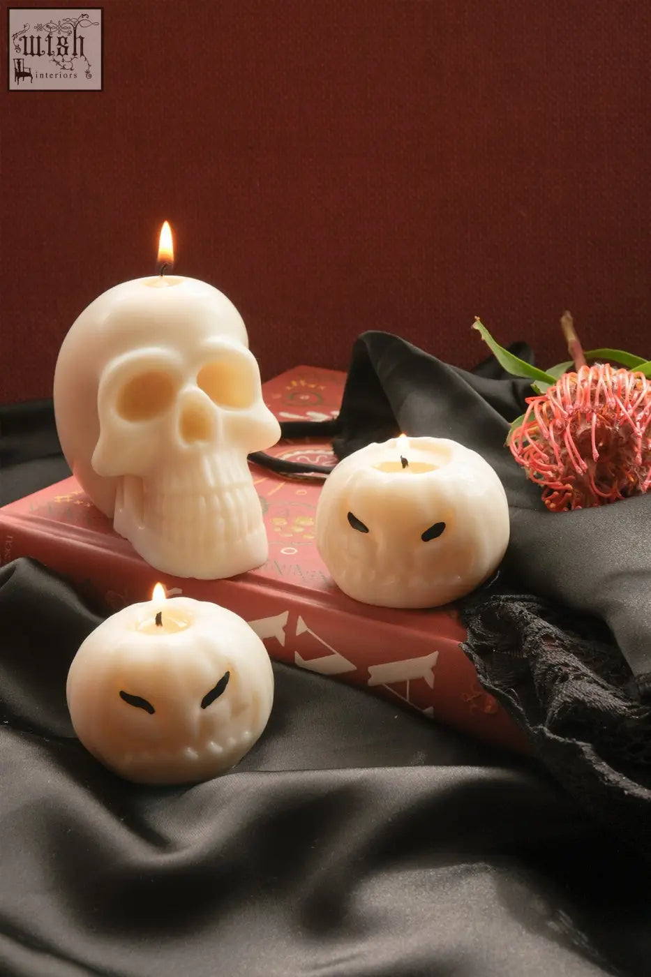 Cream-colored skull candle made of wax with a lit wick perfect for spooky decor and ambiance