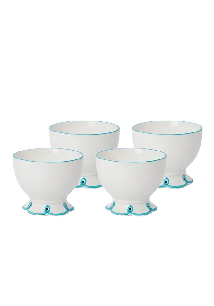 Set of four white ceramic egg cups with sky blue trim and eye-like motifs perfect for nibbles and snacks