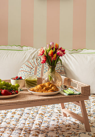 Woven rattan tray with sky blue scalloped nibbles bowl set holding colorful tulips and assorted pastries grapes berries