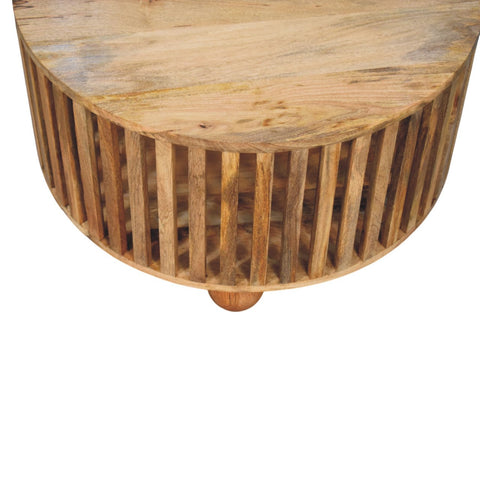 A rustic slatted round oak-ish coffee table made of solid mango wood with vertical slats and bun wooden feet