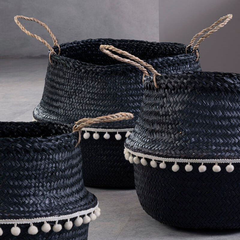 Small black seagrass basket with natural fiber handles and white pom-pom trim perfect for storage and decor