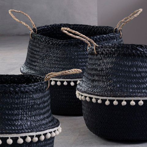 Small black seagrass basket with natural fiber handles and white pom-pom trim perfect for storage and decor