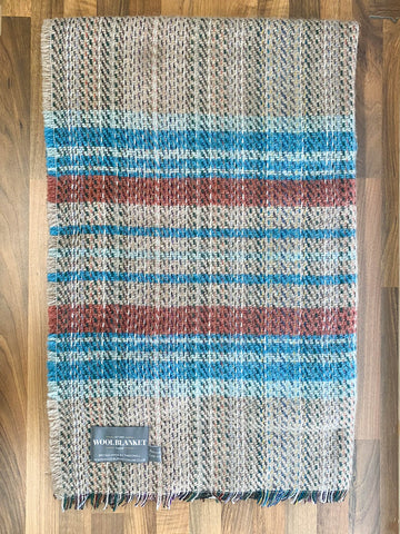 Small checked random recycled wool blanket with cozy handwoven teal blue and rust red stripes on beige background