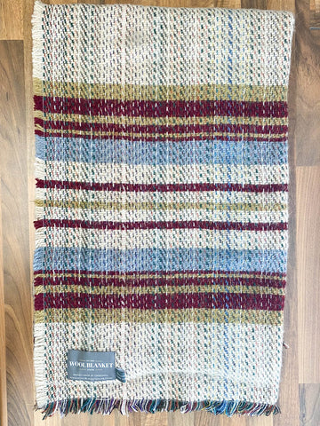 A small checked random recycled wool blanket with horizontal stripes in cream maroon blue and olive green