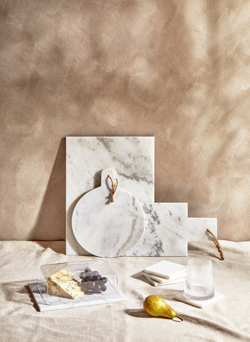 Small white marble chopping and serving board with gray veining and round handle from salerno collection