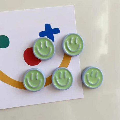 Five pastel green smiling glow fridge magnets with light blue borders in a glow fridge magnet pack on colorful paper
